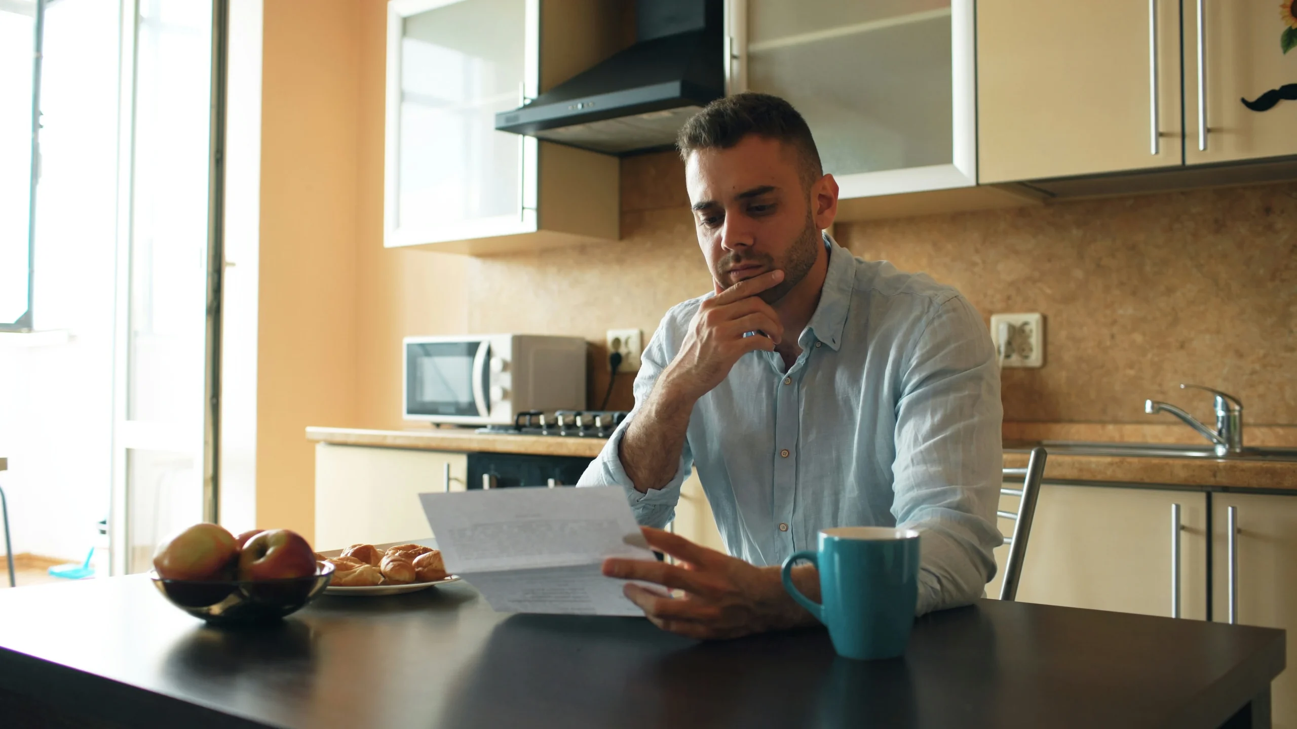 Buyer reviewing contract paperwork at a kitchen table